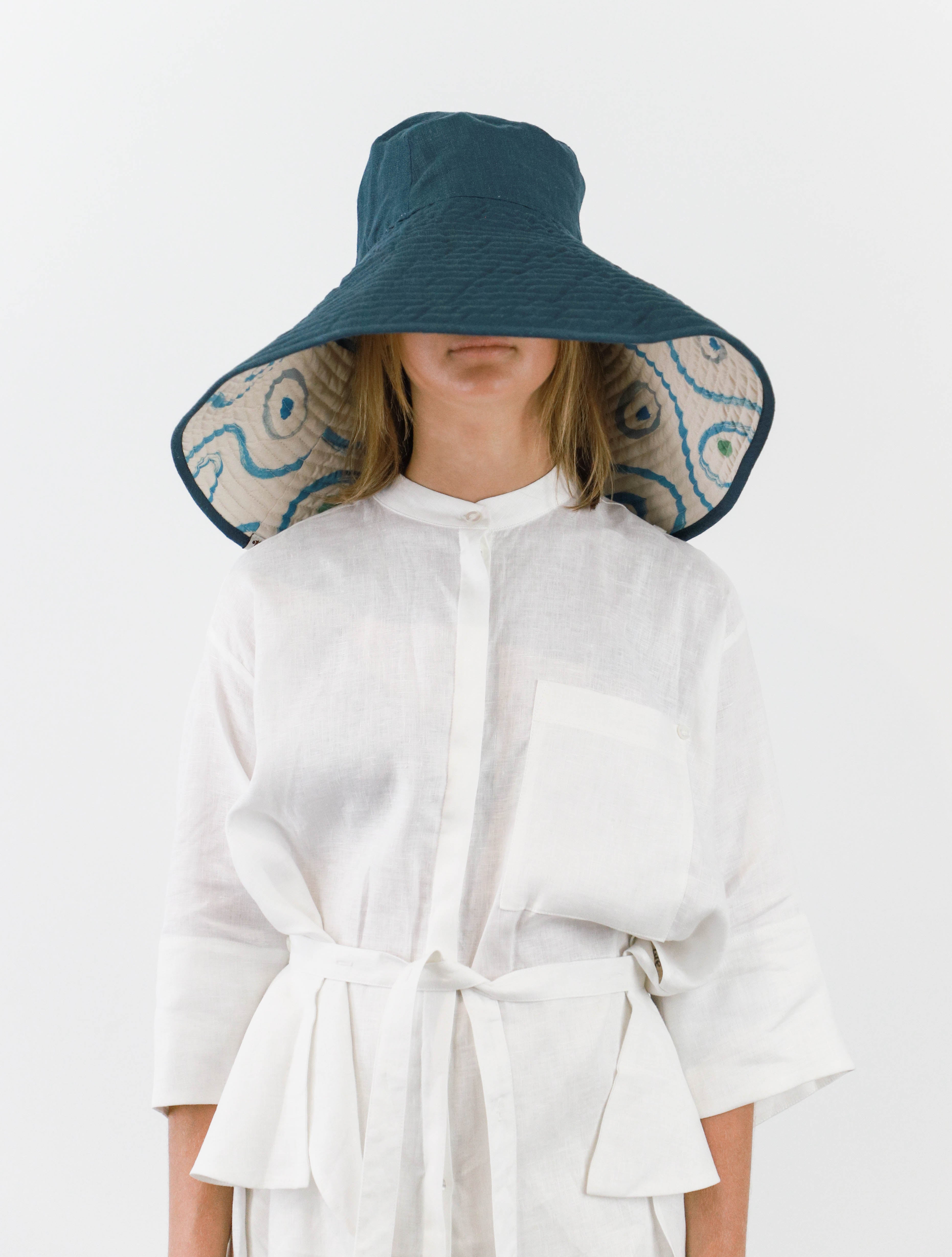 Romualda Baboomba Grande bucket hat with blue and white swirl print shown on model worn inside out with blue lining