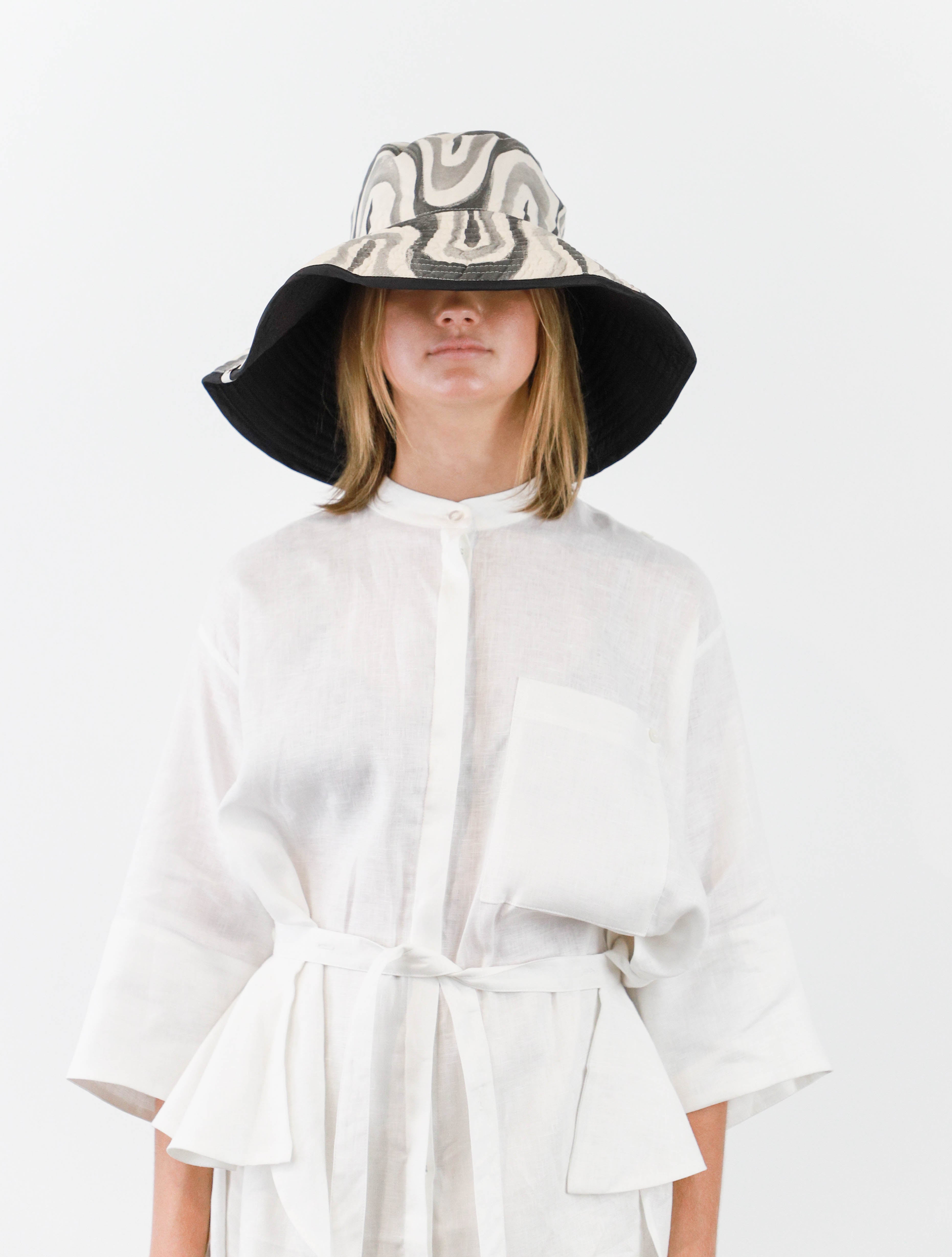 Romualda Roca bucket hat with black and white swirl pattern and black lining shown on model 